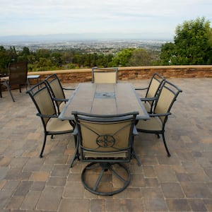 dining table on top of a paver patio with view of the city below. 